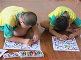學員雙手拿不同顏色的蠟筆，同時進行塗色。